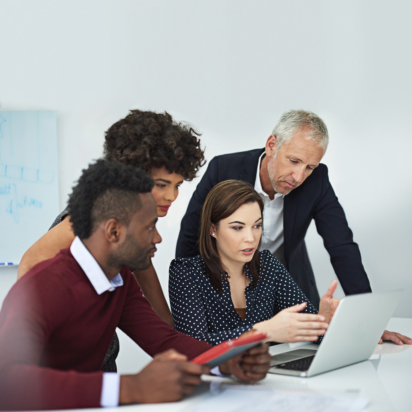 Cropped shot of a group of businesspeople discussing something on a laptop